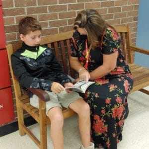 SHES principal Kristen Tormey reading with student