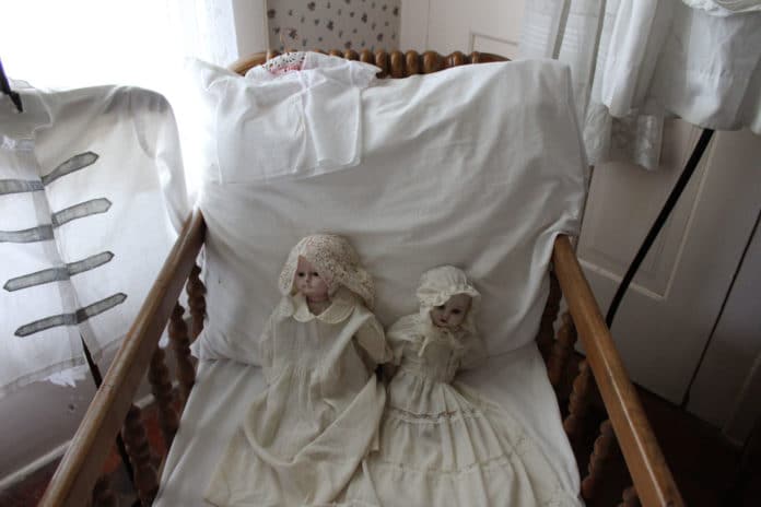 Dolls on display in Jesse May's room at the May Stringer House. The doll on the left is said to be one of the most haunted items in the house.