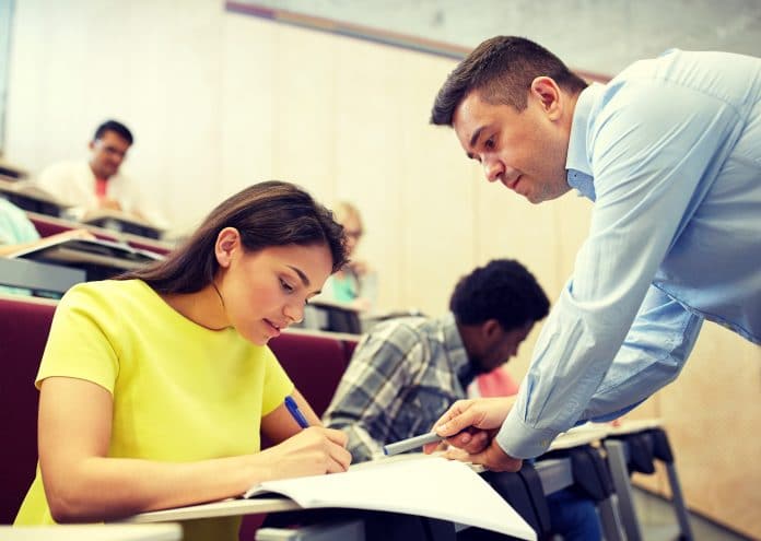 education, high school, teaching, university and people concept - group of international students and teacher at lecture hall via AdobeStock