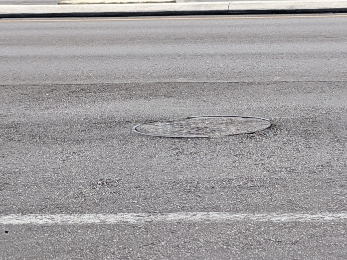 Manhole cover uneven with asphalt
