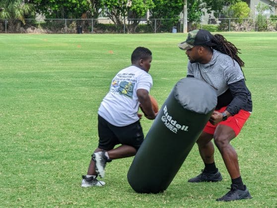 Dujuan Harris performs running back drill with player