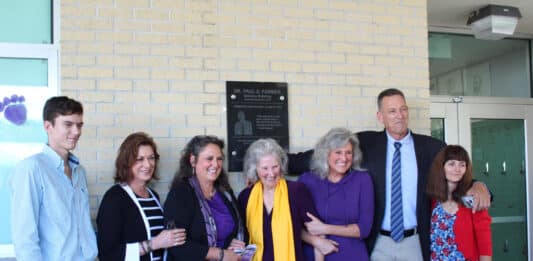 The family of Dr. Paul Farmer in front of the plaque commemorating his legacy at Hernando High School.