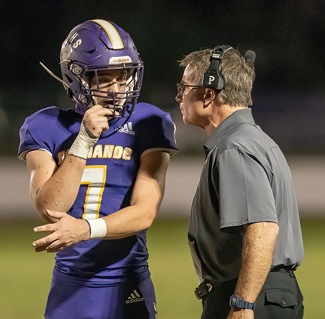 Hernando High, 7, James Belmont confers with Head Coach John Scargle between plays during the Homecoming game against Crystal River. Photo by JOE DiCRISTOFALO