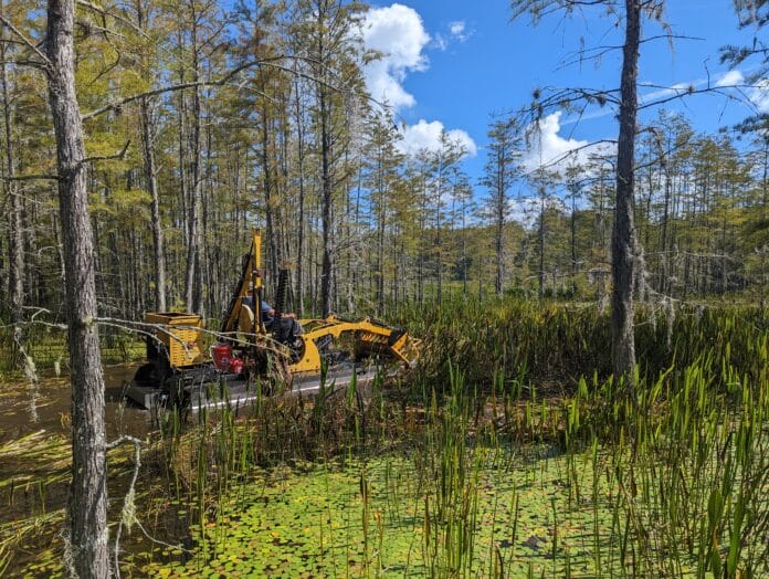 John Meeks operates a harvester to clear vegetation from a lake in Brooksville.