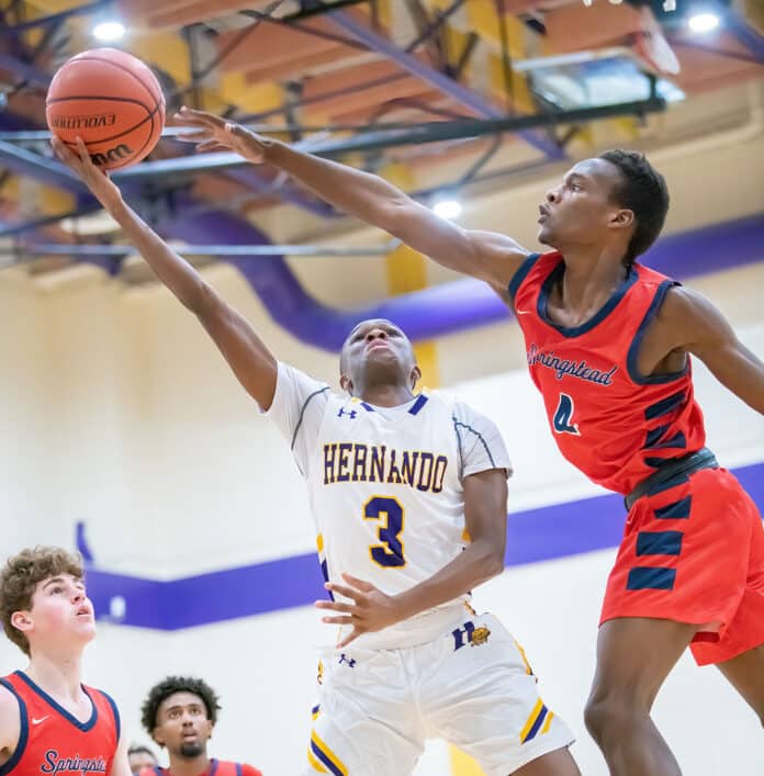 Hernando High, 10, Michael Saavareseshoots over Springstead high, 20, Andrew Danchese. Photo by JOE DiCRISTOFALO