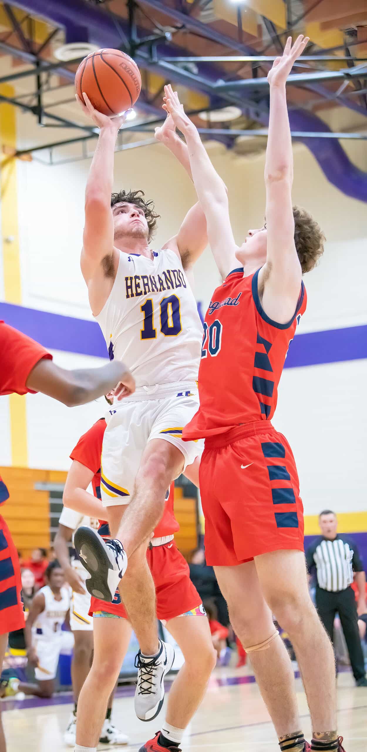 Hernando, 3, Josiah Wright extends to lift a shot past the defense by Springstead High, 4, Caidell Gilbert Tuesday 1/3/23 at Hernando High. Photo by JOE DiCRISTOFALO