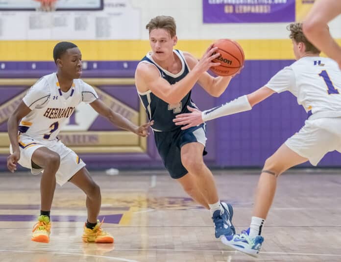 Central High, 4, Braden Joyner tries to spli tHernando defenders Josiah Wright ,3, and Drew Bittinger ,1, on his way to the basket Tuesday 1/17/23 in Brooksville. Photo by JOE DiCRISTOFALO