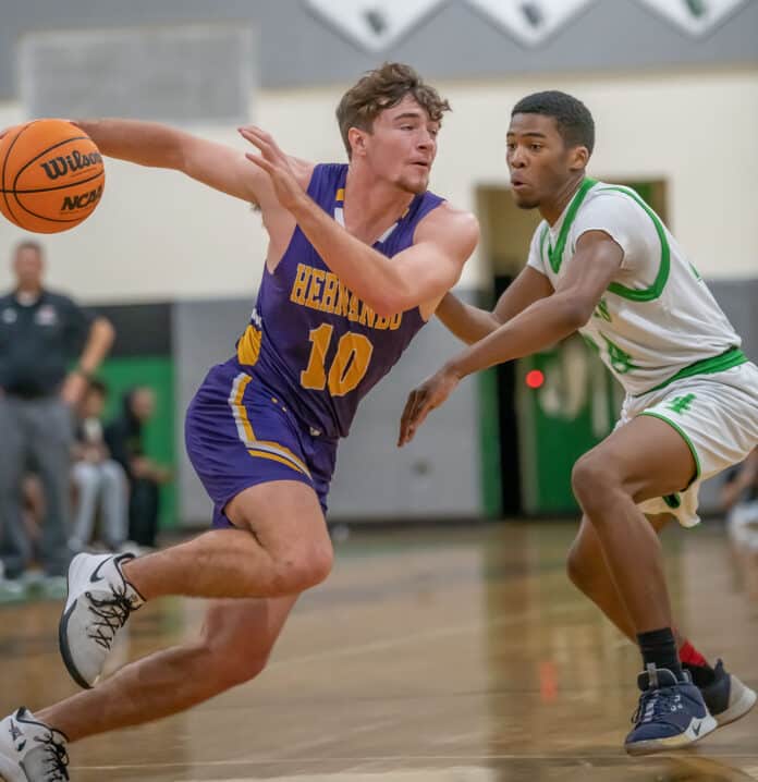 Hernando High, 1o, Michael Savarese goes hard around the defense by Weeki Wachee, ,24, Anthony Wilson Tuesday 1/24/23 in Brooksville. Photo by JOE DiCRISTOFALO