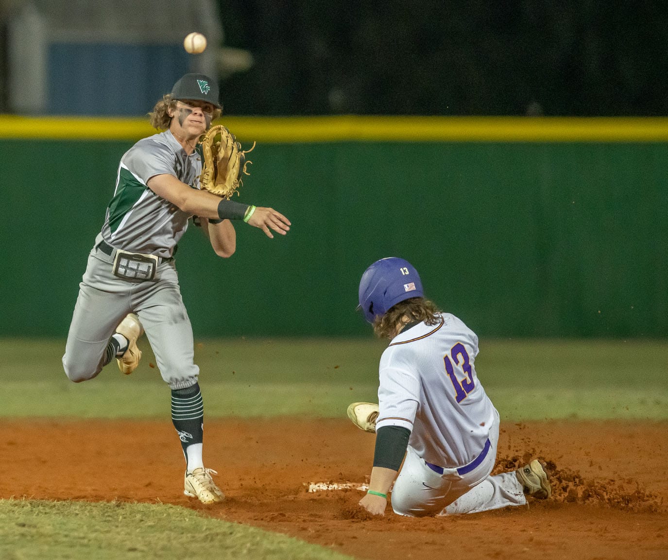 Weeki Wachee shortstop Jayden Vigo attempts to turn a double play after forcing out Hernando High’s ,13,Henry Robinson Tuesday in Brooksville. Photo by JOE DiCRISTOFALO