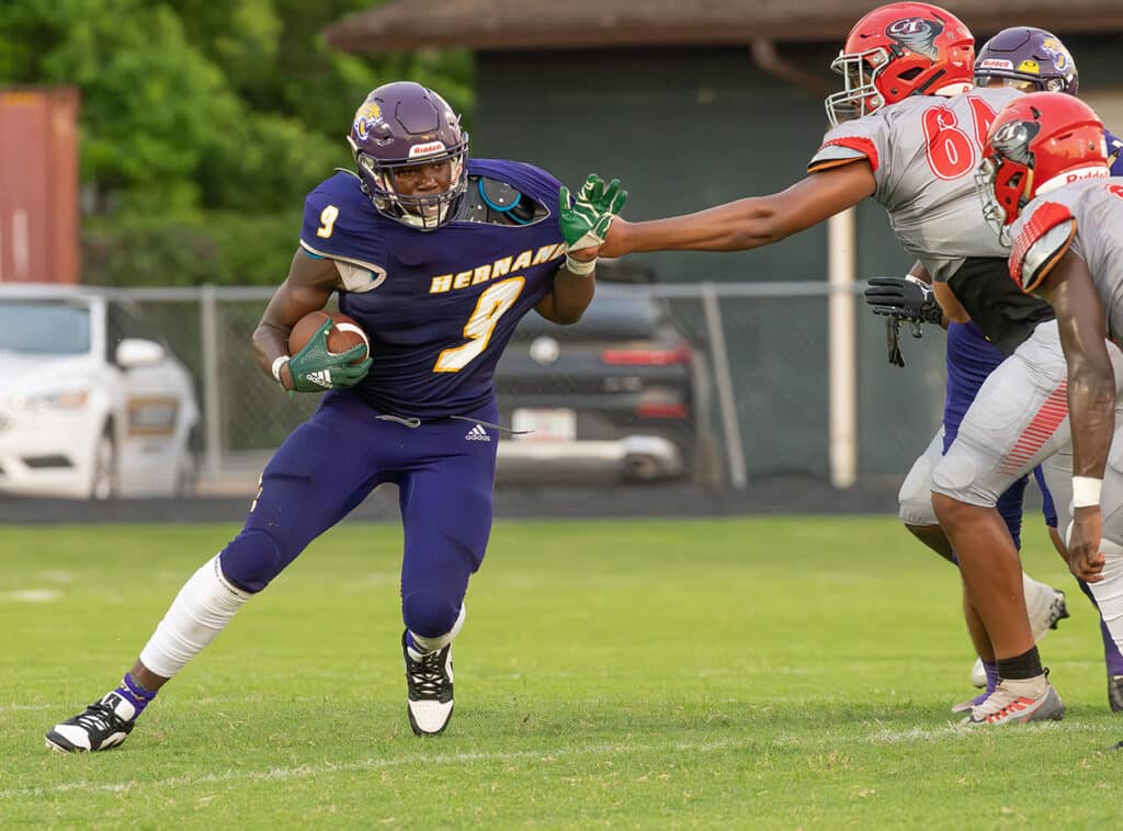 Hernando High’s ,9, John Capel III, tries to break the grasp of a Clearwater High defender during Friday nights home preseason game. Photo by JOE DiCRISTOFALO