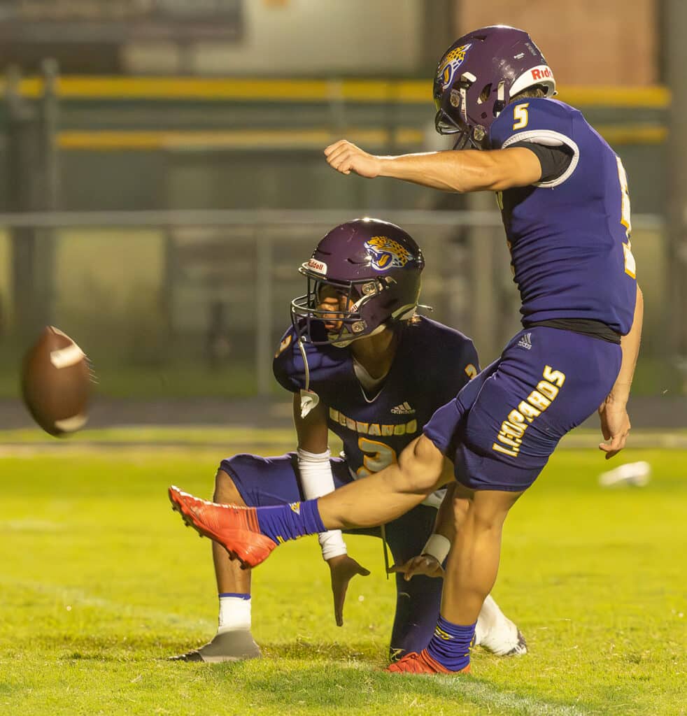 Hernando place kicker ,5, Jesse Foulks drives an extra point out of the hold by Angel Garrestequi, 3, after a touchdown run by Michael Saltsman. Photo by JOE DiCRISTOFALO