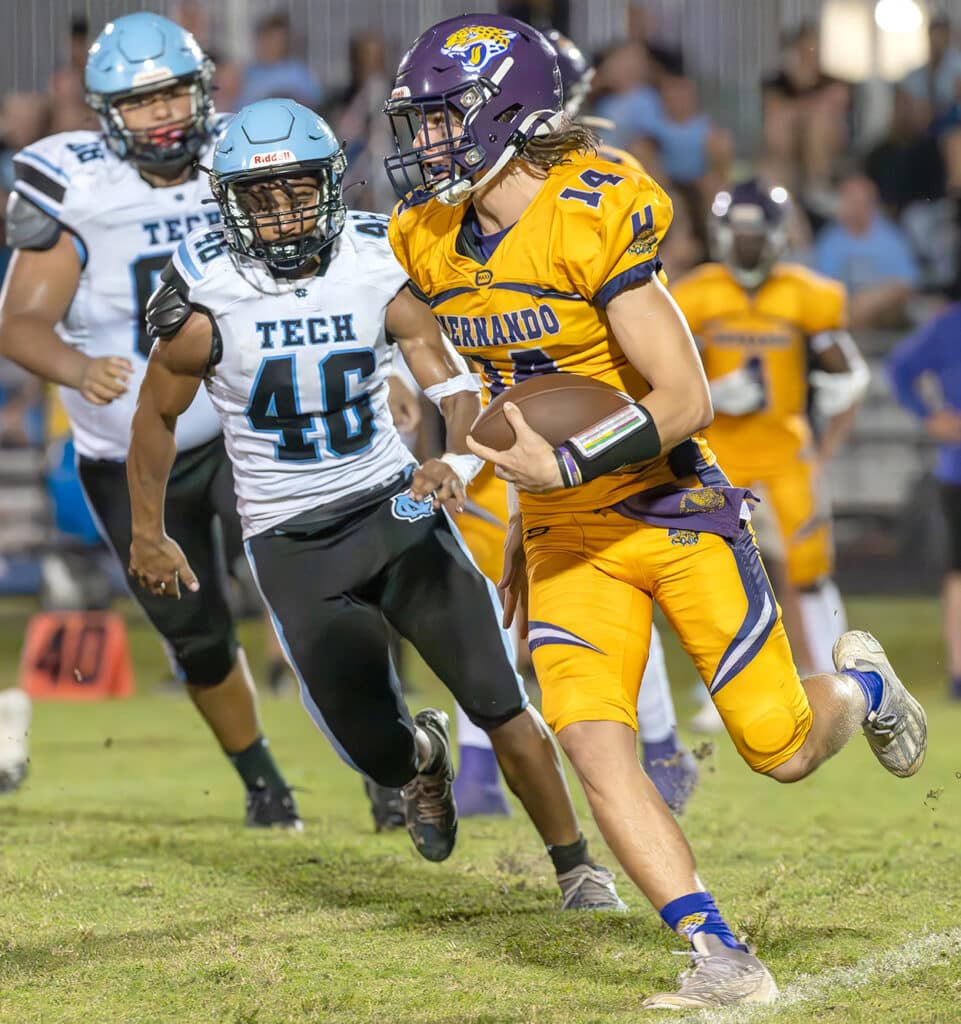 Hernando High QB, 14, Michael Saltsman, escapes the pocket and pursuit by NCT, 46, Donovan Mangozho Friday night in Brooksville. Photo by JOE DiCRISTOFALO