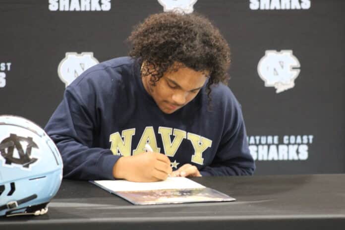 Cromer signs a letter of intent to attend the Naval Academy. [Credit: A. Szempruch]