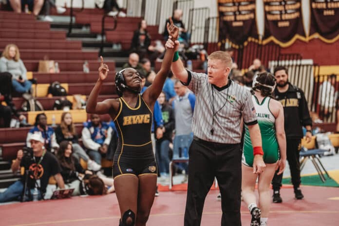 Makenzie Eltzroth gets her hand raised after taking first at the first annual Women of Ironman tournament. [Credit: Cynthia Leota]