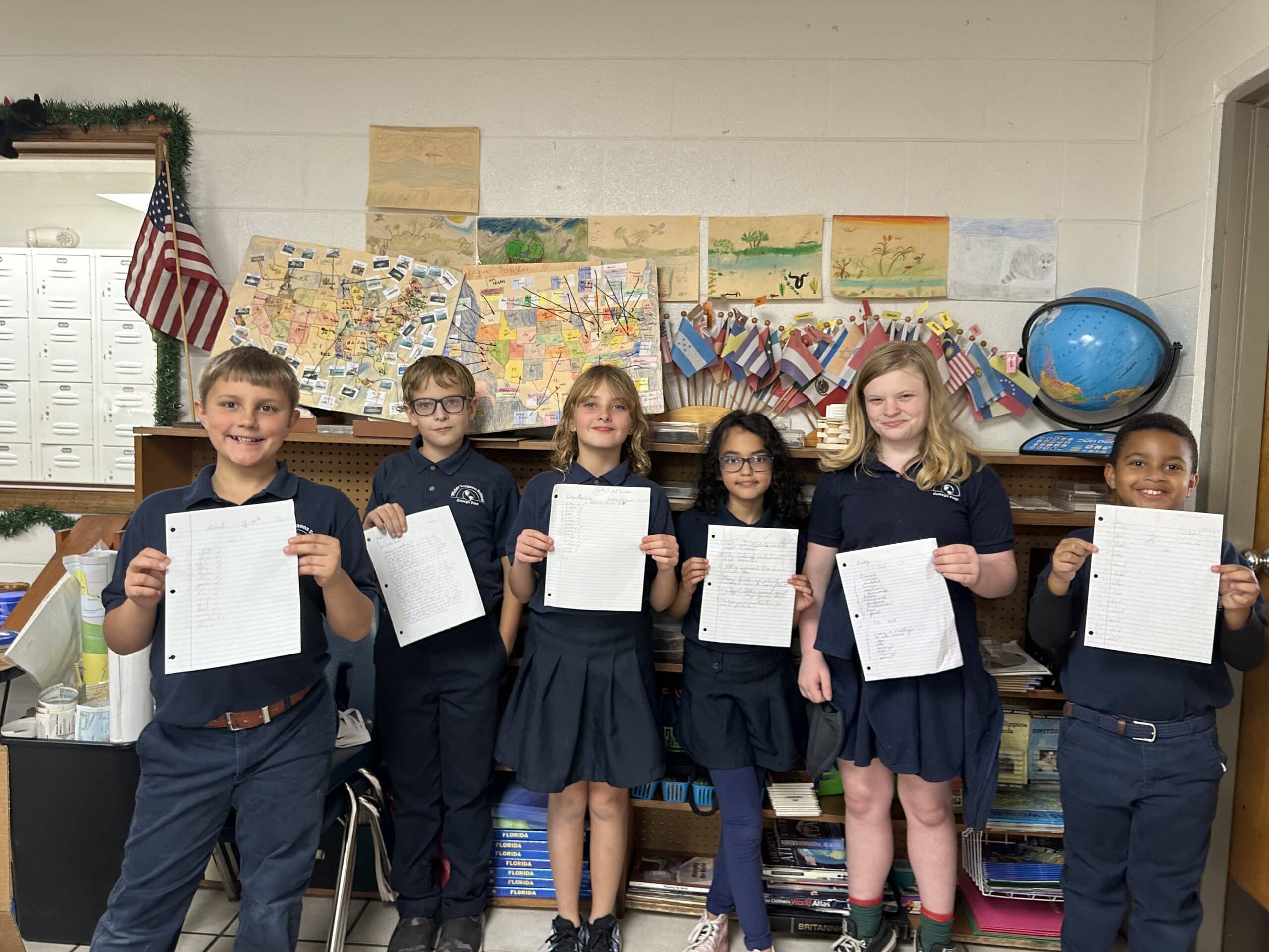 Upper elementary students hold up their letters to Florida National Guard members. [Courtesy Photo]
