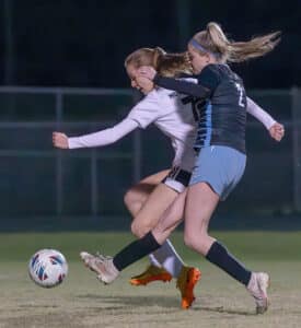 Nature Coast, 2, Hailee Wegner gets a shot off for a goal while defended by Weeki Wachee, 7, Lola Northrup  in the 4A District 6 Final held at Nature Coast Tech. [Photo by Joe DiCristofalo]