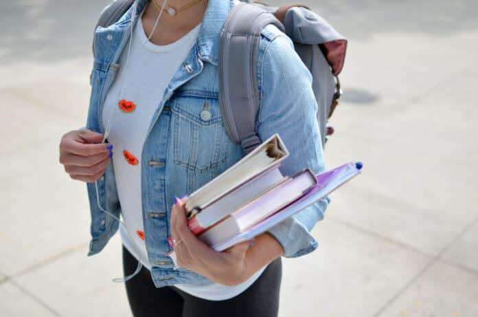 Student holding books. [Photo by Element5 Digital on Unsplash]