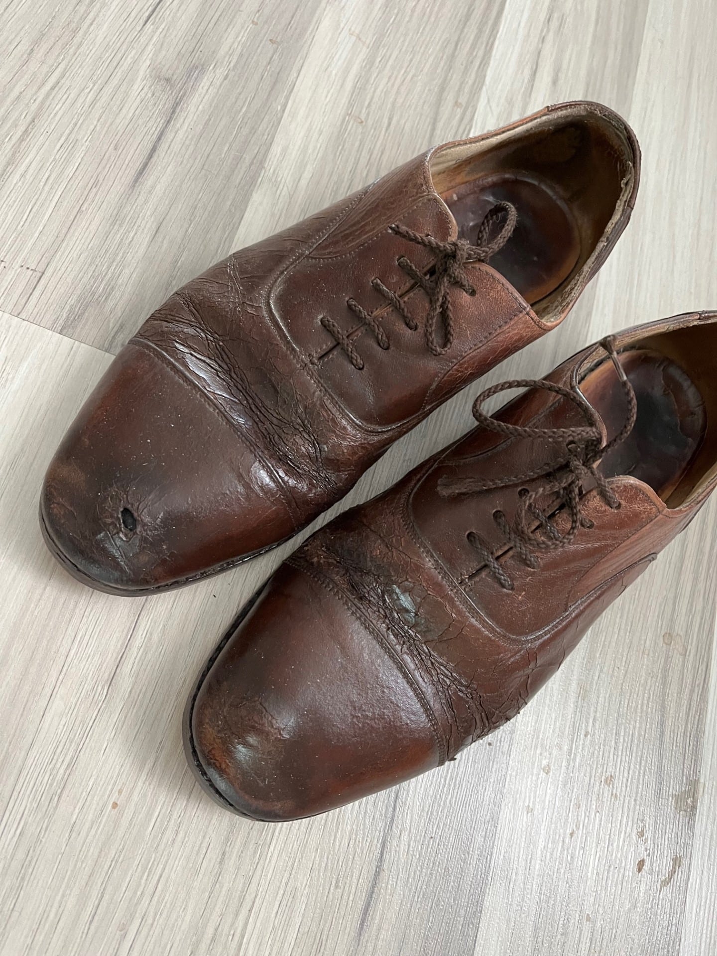 Shoes after repair. Conditioned, polished and shining. New soles and heels and a small patch (known as a King Charles III patch) help mask the hole in the toe.