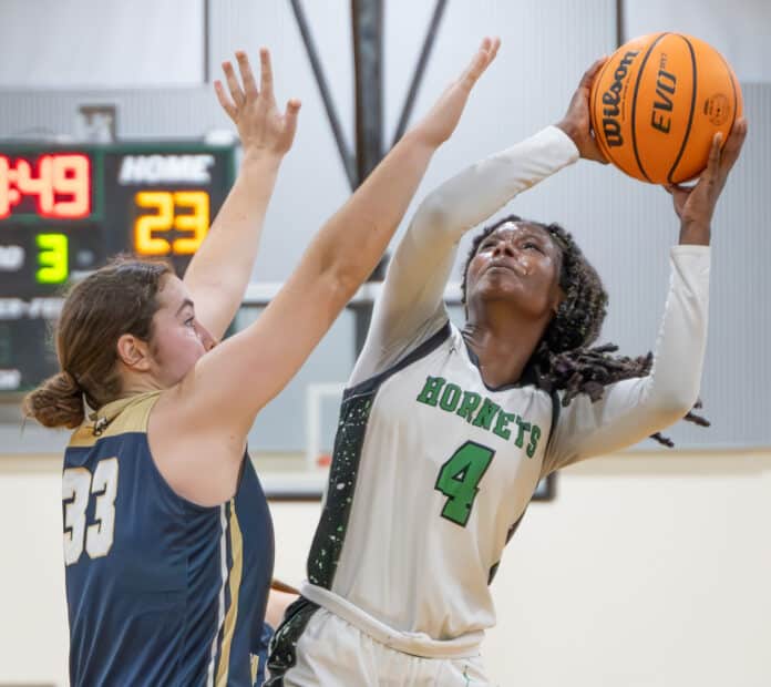 Weeki Wachee, 4, Nevaeh Clark shoots while defended by Academy of The Holy Names, 33, Morgan Hunt in the 4A Region quarterfinal game held at Weeki Wachee High School. [Photo by Joe DiCristofalo]