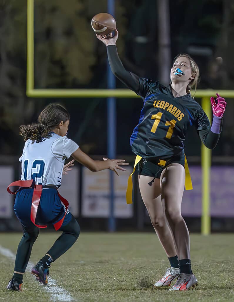 Hernando High QB, 11, Aislin Ruppe gets off a pass before the rush by Central High ,12, Hailey Diaz at Hernando High Thursday night. [Photo by Joe DiCristofalo]