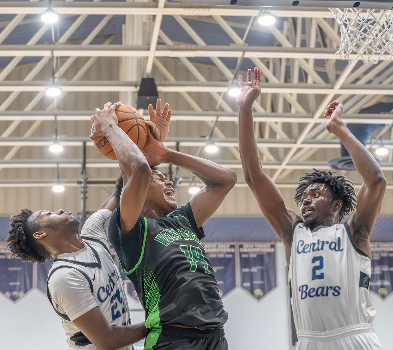 Weeki Wachee High, 14, Isaac Priester draws the attention of Central High, 2, Jerome “JD” Watson and ,25, Tykel Williams in the 4A District 9 semifinal at Central High Thursday night. [Photo by Joe DiCristofalo]