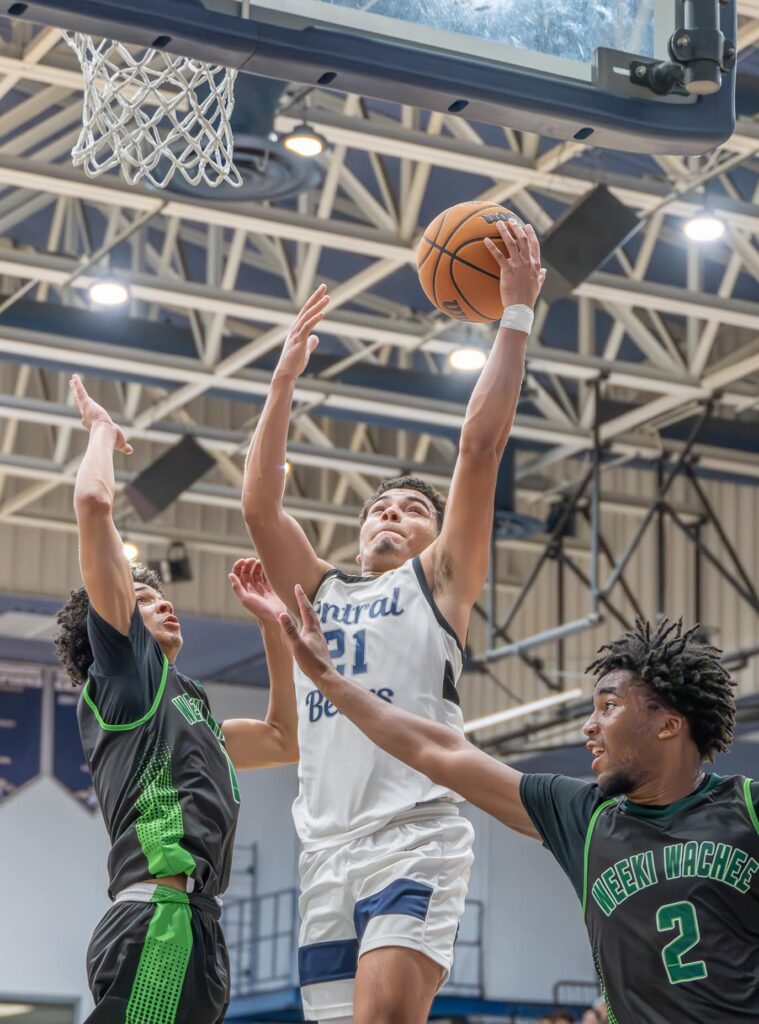 Central High, 21, David Villarroel elevates for a shot while defended by Weeki Wachee High, 1, Jean Garcia and, 2, Alex Wilson. [Credit: Joe DiCristofalo]