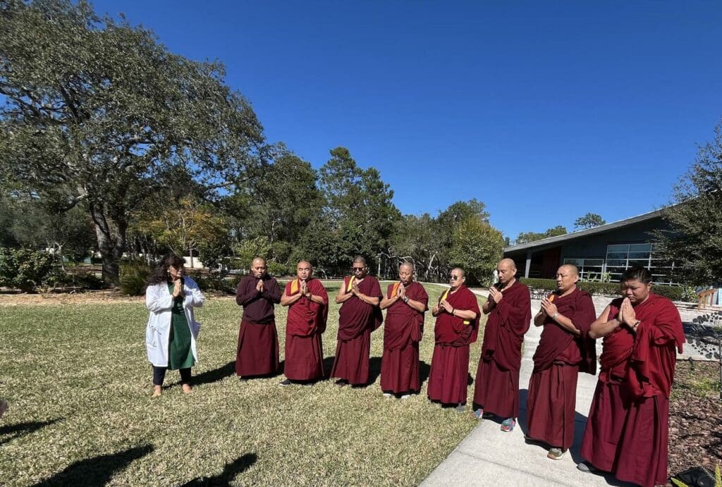 Dr. Scunziano-Singh stands with Sacred Arts Tour Monks as they chant Om for Deep Meditation and Spiritual Awakening.