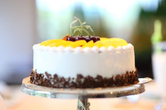 White frosted cake with fruit slices.