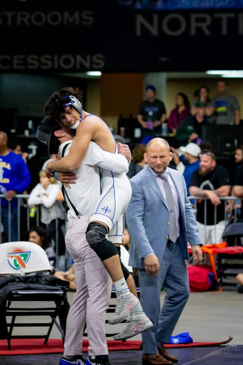 McCall celebrates his state final victory with Jesuit coach David Mason as Jesuit coach Sal Basile looks on. [Courtesy Photo]