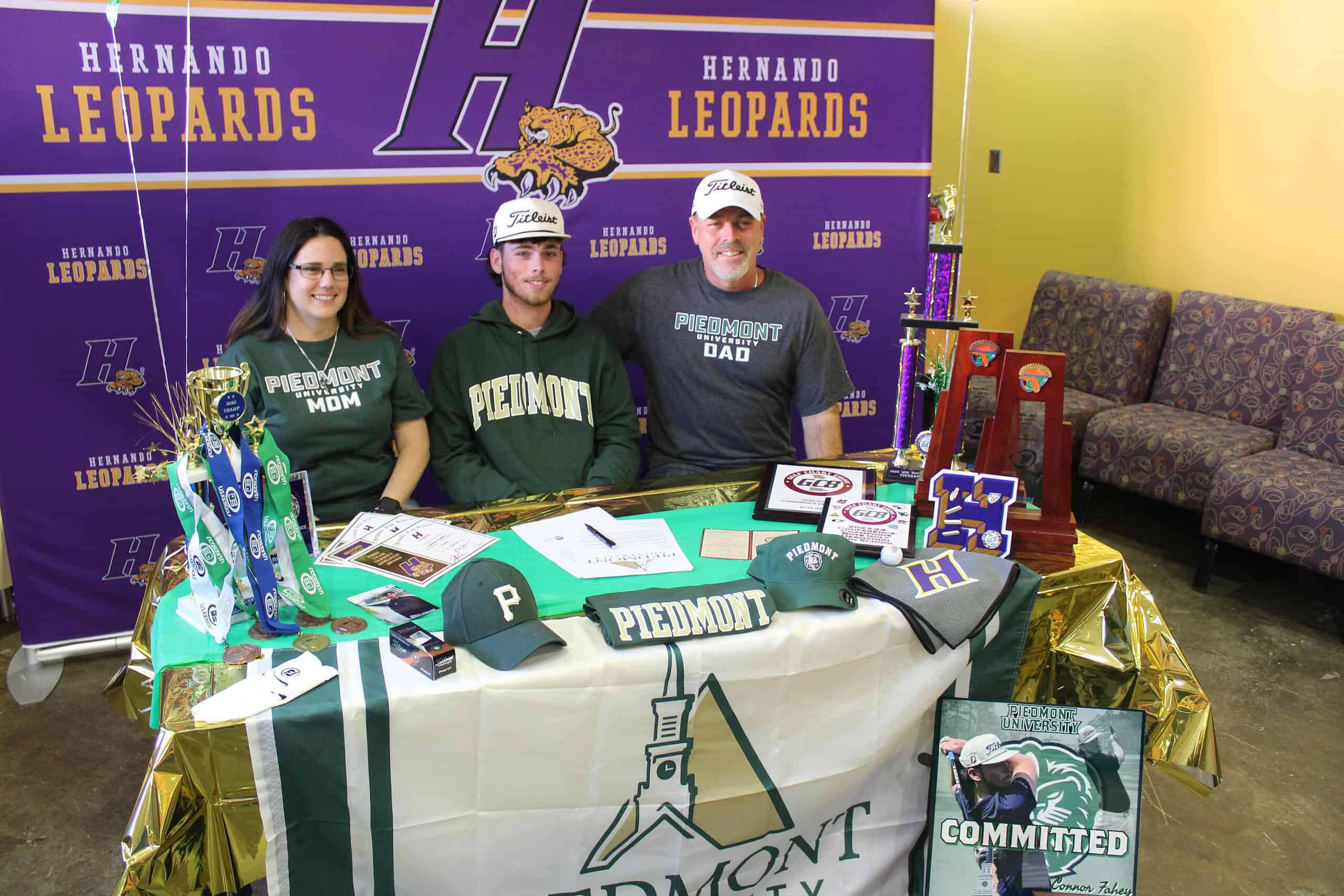 Connor Fahey (middle) poses for a photo with his father, Dennis (right), and mother, Jennifer (left), during Tuesday’s signing ceremony. [Credit: A. Szempruch]