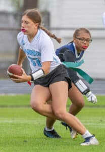 Nature Coast QB, 17, Madelyn DePetrillo eludes the reach of Central High’s, 4, Sharell Burton. [Photo by Joseph DiCristofalo]