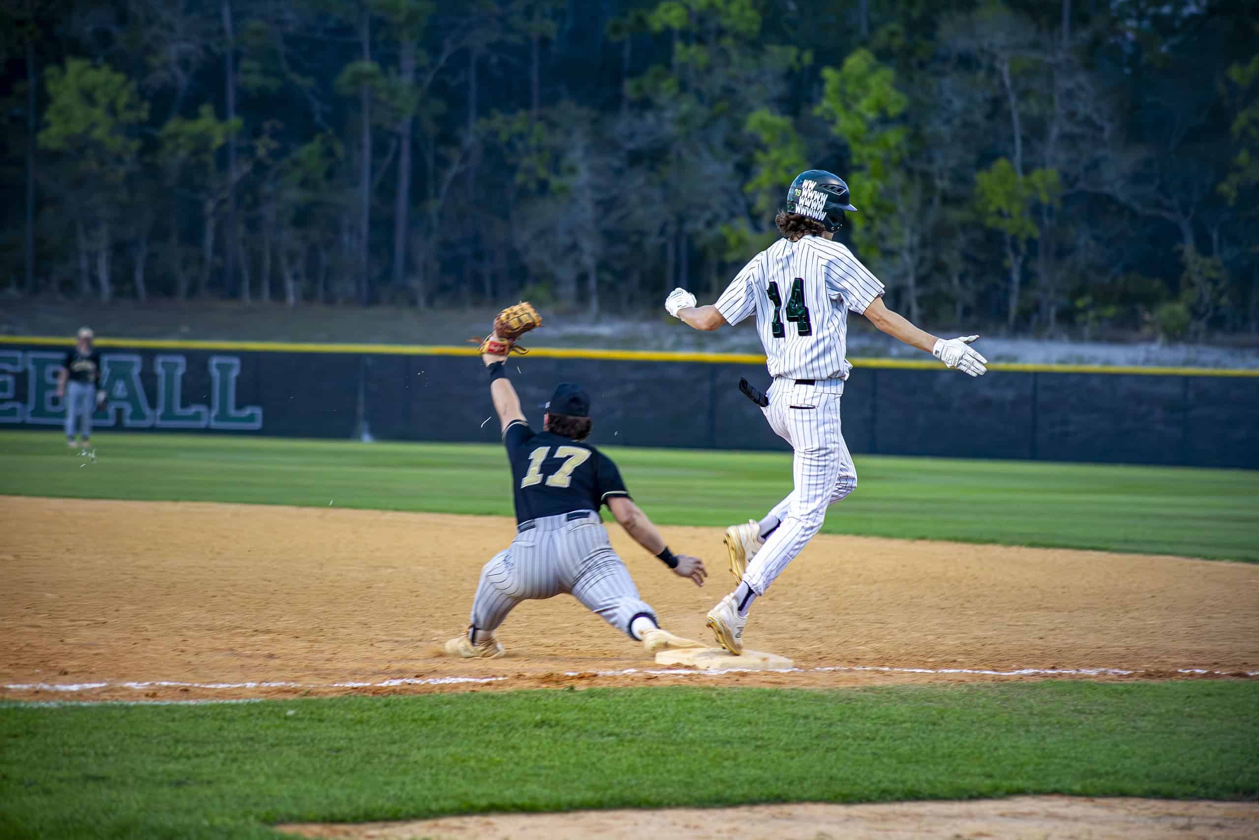 Citrus's Austin Barry stretches to catch the ball while Weeki Wachee's Jack Strong runs to first base. [Photo by Hanna Maglio]