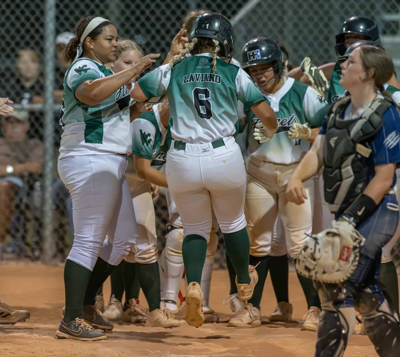 Weeki Wachee High Captain, 6, Taylor Laviano jumps onto home plate before being met by her teammates after her third home run, which proved to be the winning run against visiting Central High in the 4A District 5 playoff game . Photo by [Joseph Dicristofalo]