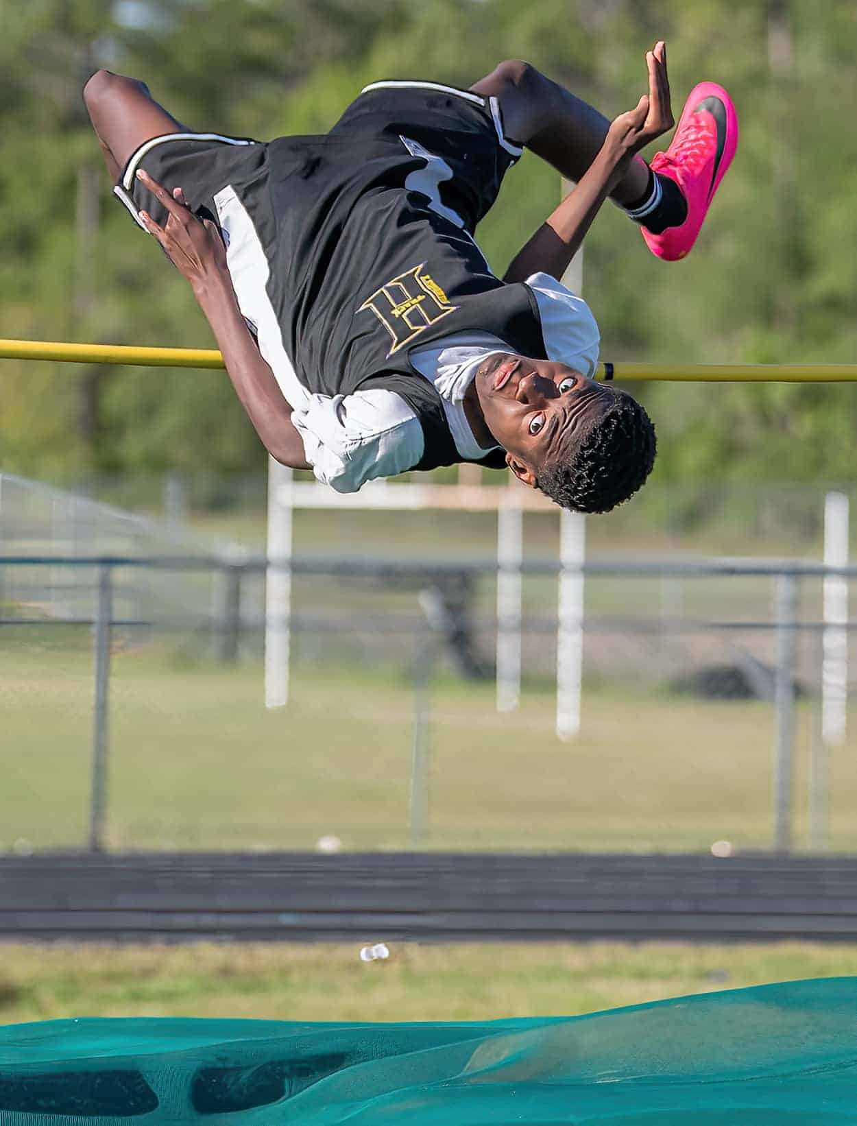 Hernando High’s Dakendrick Miller concentrates on his landing spot after a successful high jump attempt at the GC8 Track and Field Championships at Weeki Wachee High School. Photo by [Joe DiCristofalo]