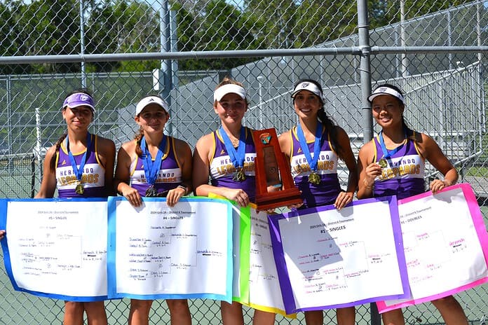 Hernando High's girls tennis team celebrates with its district championship trophy and medals. Photo by Chris Bernhardt Jr.