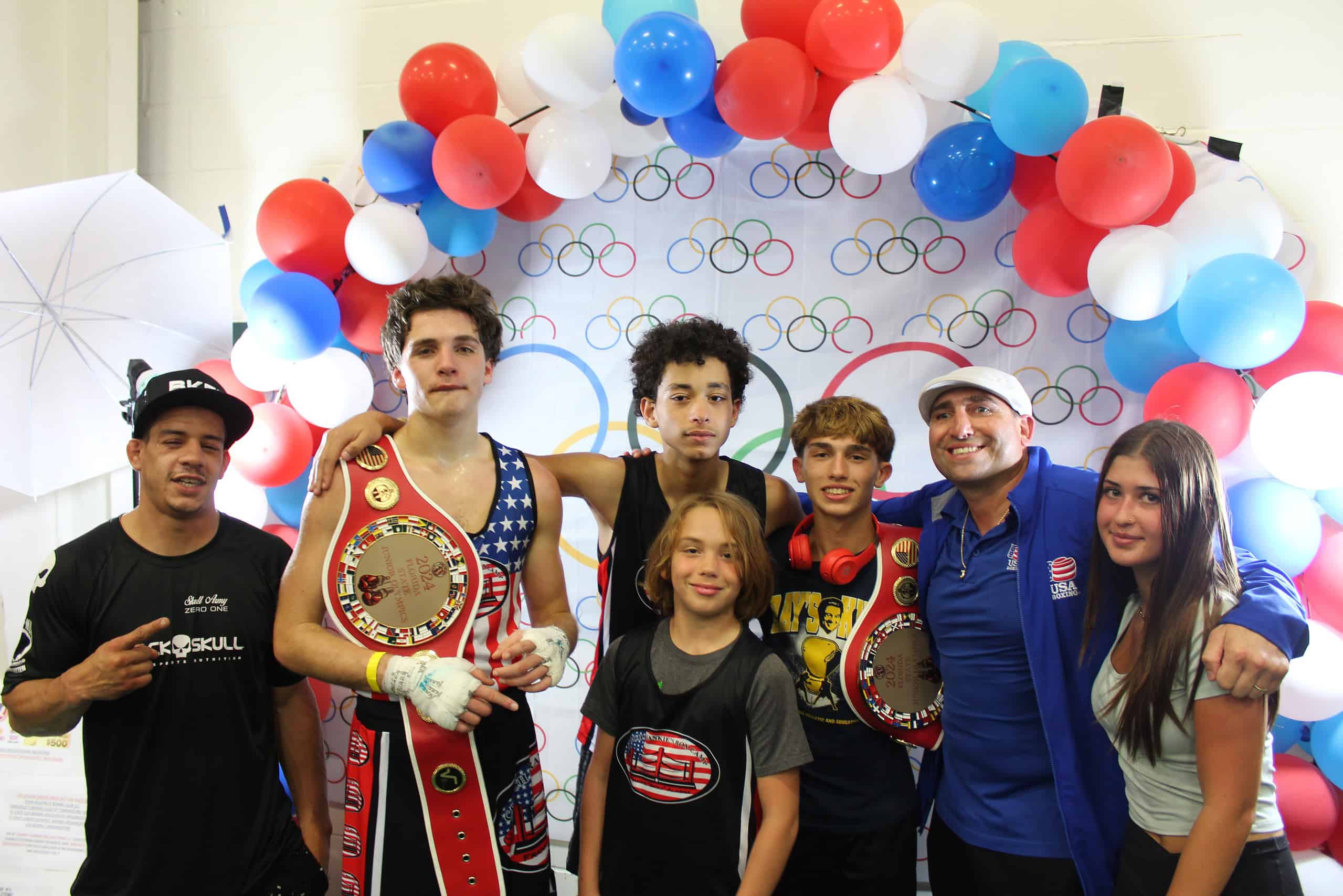 Coach Alagna, fighters, and family pose for pictures during the Junior Olympics.