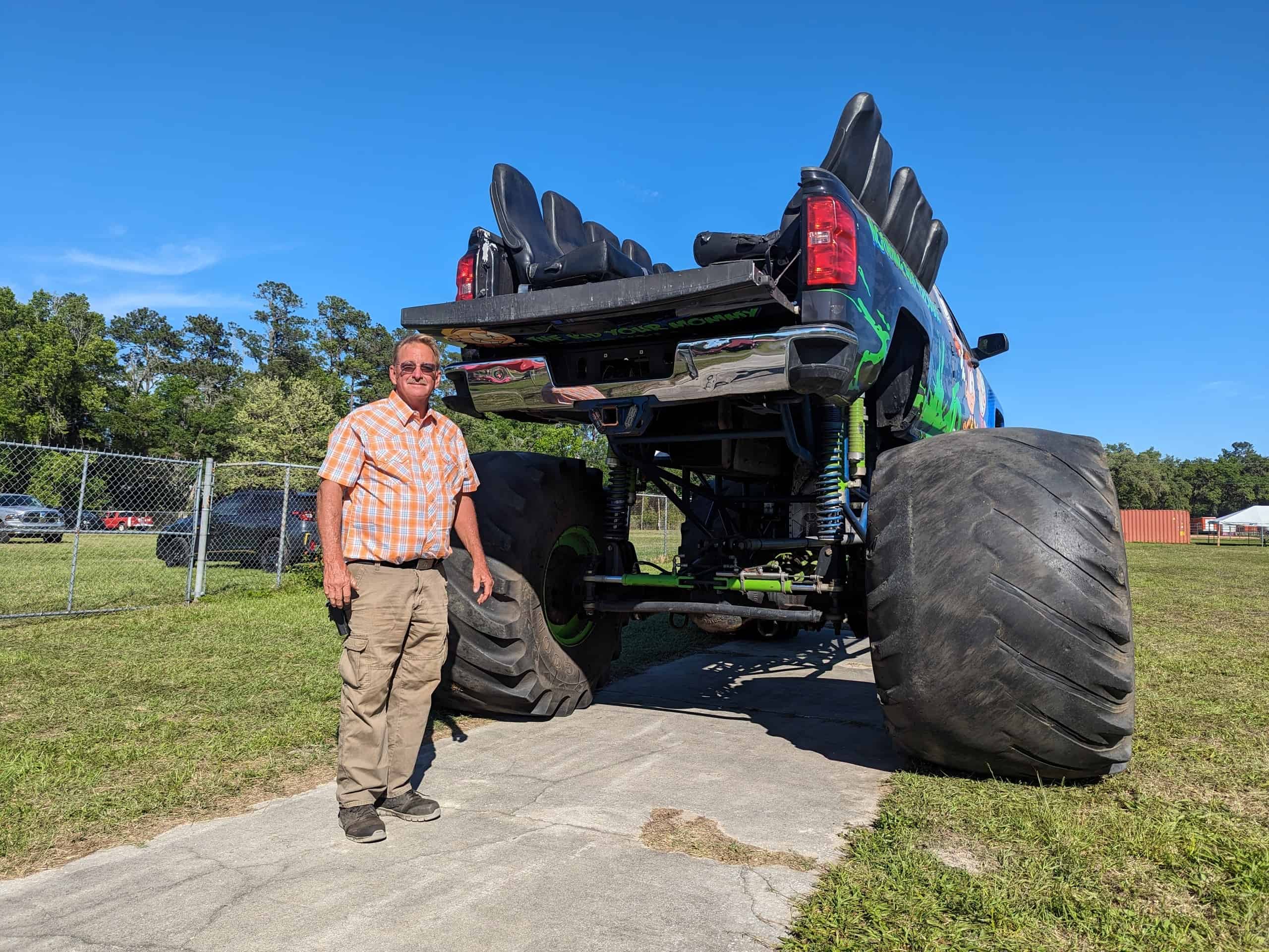 Fair organizer Richard Klimas in front of the monster truck to demonstrate size