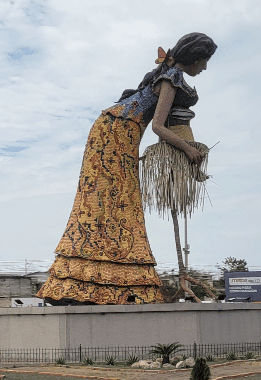 She’s big at 15m high. She’s a statue weaving a panama hat but located in the middle of a busy roundabout. 