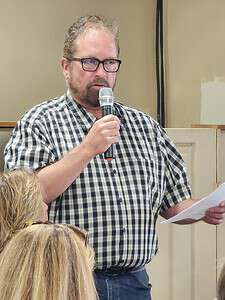 Engineer and affected homeowner Tim Collins speaks about issues surrounding the lagoons construction at Thursday's meeting. [Photo by Austyn Szempruch]