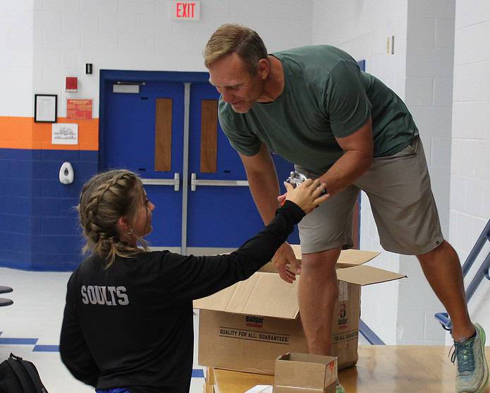 Challenger Head Coach David Barrett hands an award to athlete Amanda Soults on Thursday at Challenger K-8. [Photo by Austyn Szempruch]