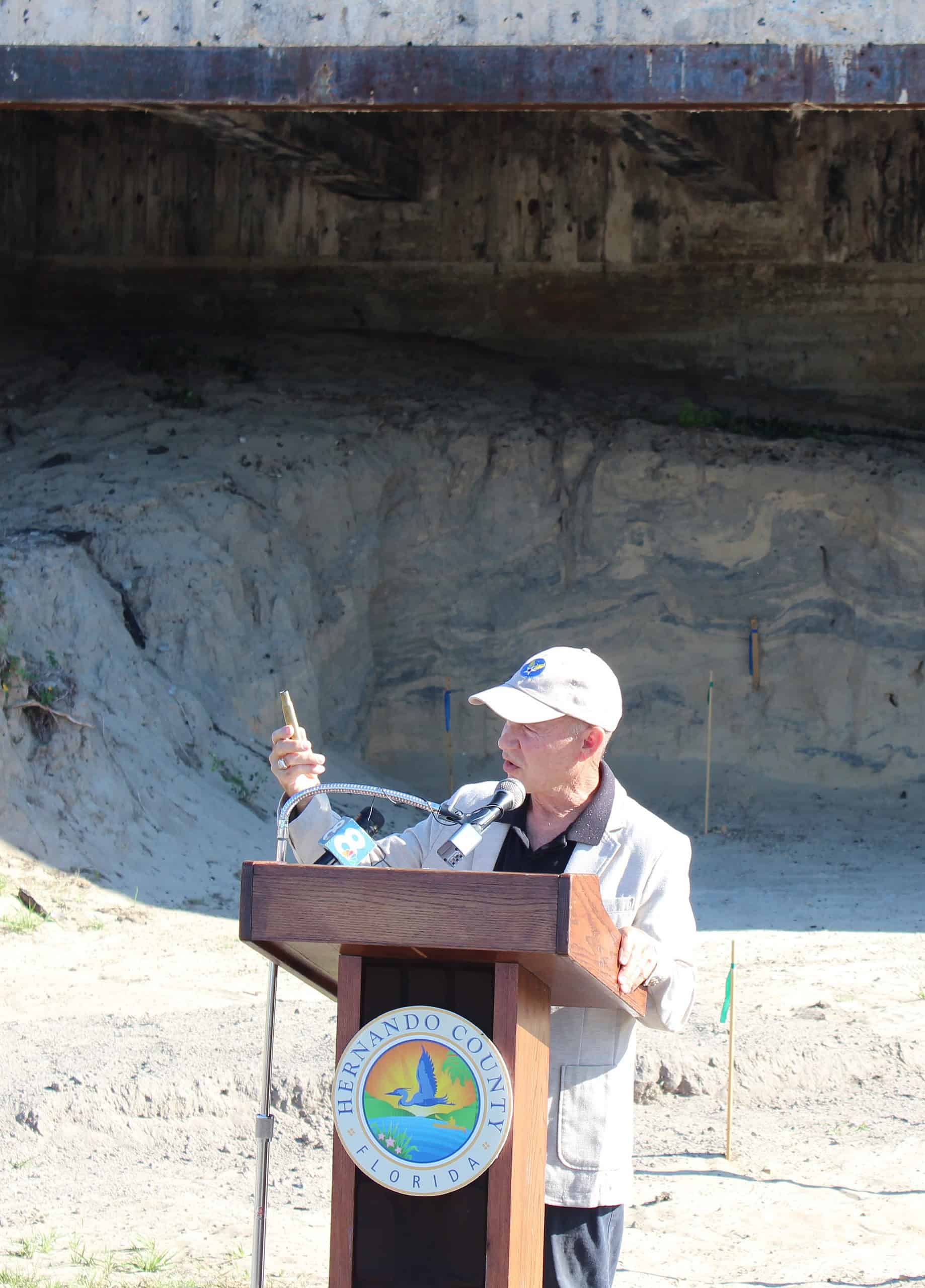 Local historian and pilot Don Etchison gestures toward a .50 caliber round, the marks of which adorn the Gunnery Backstop to this day. [Photo by Austyn Szempruch]