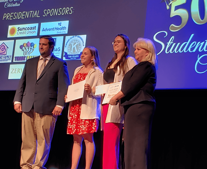 Taylor Estridge with representatives of Tropic Shores Realty [Photo by Sarah Nachin]