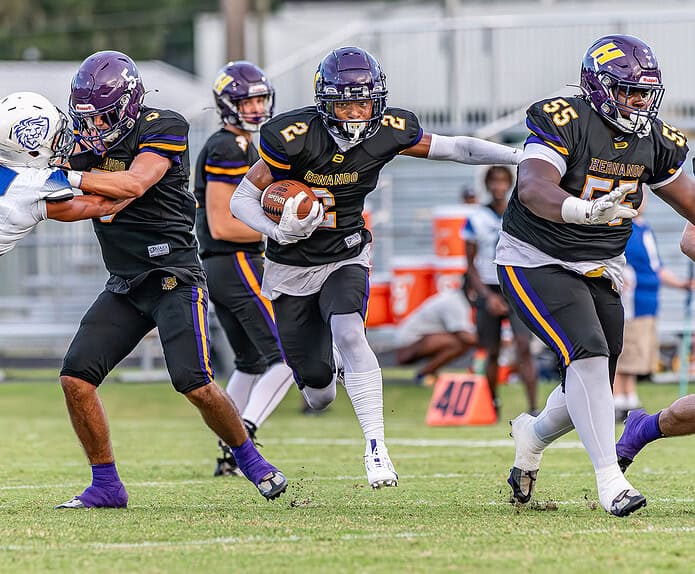 Hernando High running back, 2, Gabe Sansone uses blocks by ,5, Sam Jackson and ,55, Noah Brown against visiiting Hollins High School Friday in Brooksville. [Photo by Joe DiCristofalo]