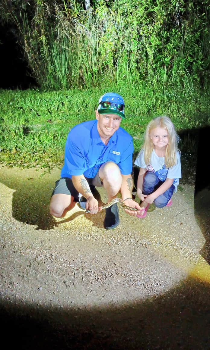 Sean Cummins, with daughter Bristol and his first ever Burmese Python caught during the Florida Python Challenge, while hunting with Toby. [Photo by Toby Benoit]