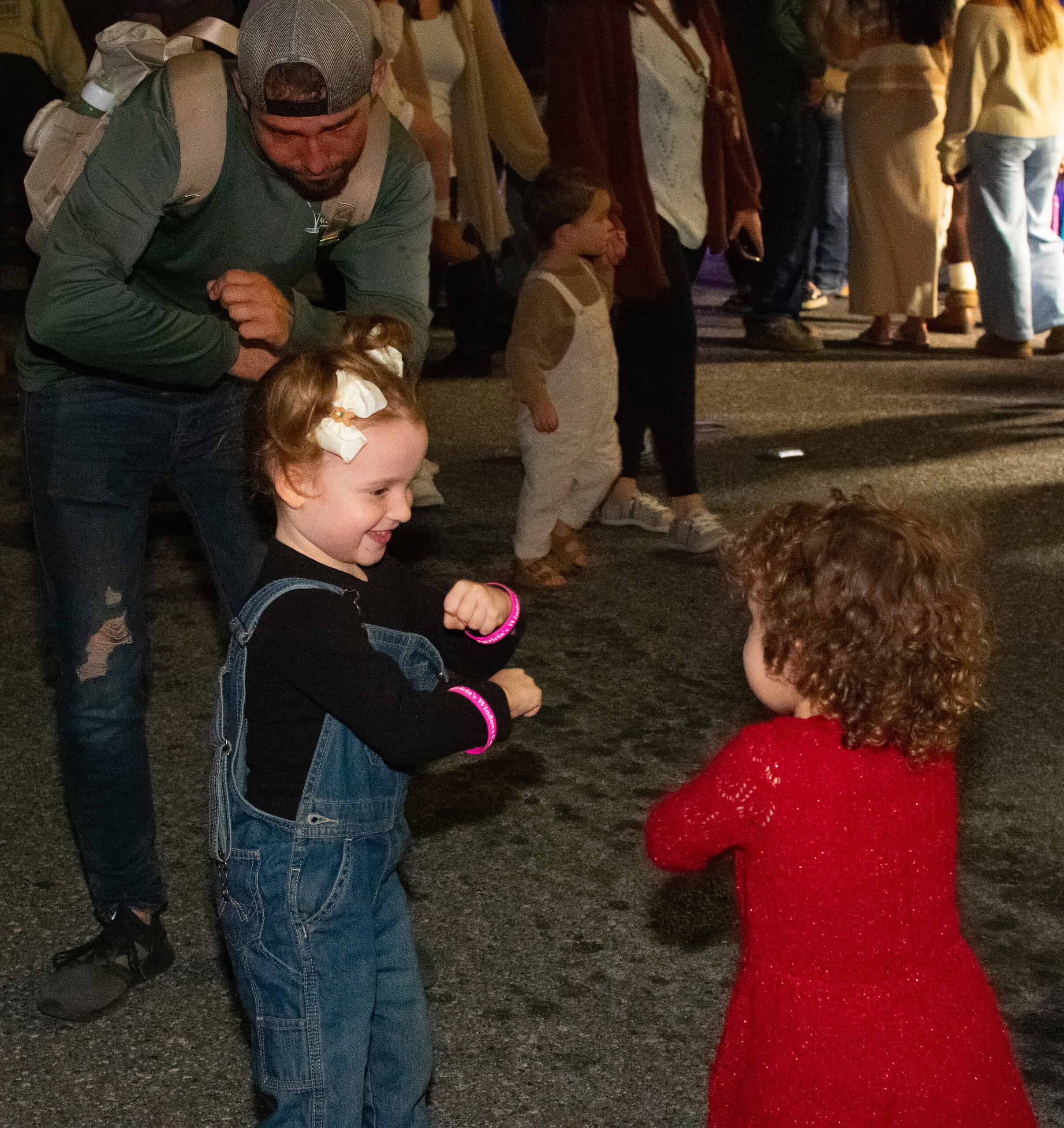 During “Windows Come To Life” best friends Opal (in red) and Haven (overalls) dance to music from Patricia’s Boutique during the Brooksville Tree Lighting December 5, 2024. [Photo by Jenifer Truitt]