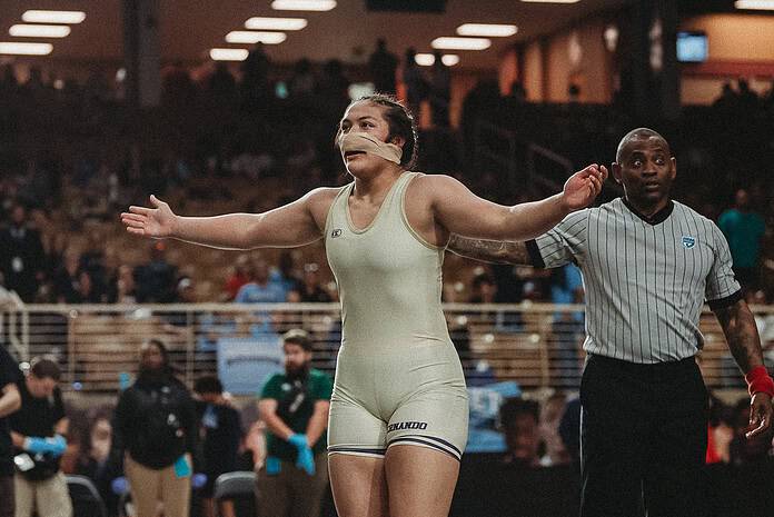 Grace Leota (SR) of Hernando faces the crowd after winning her third State Wrestling Championship Title. [Photo by Cynthia Leota]