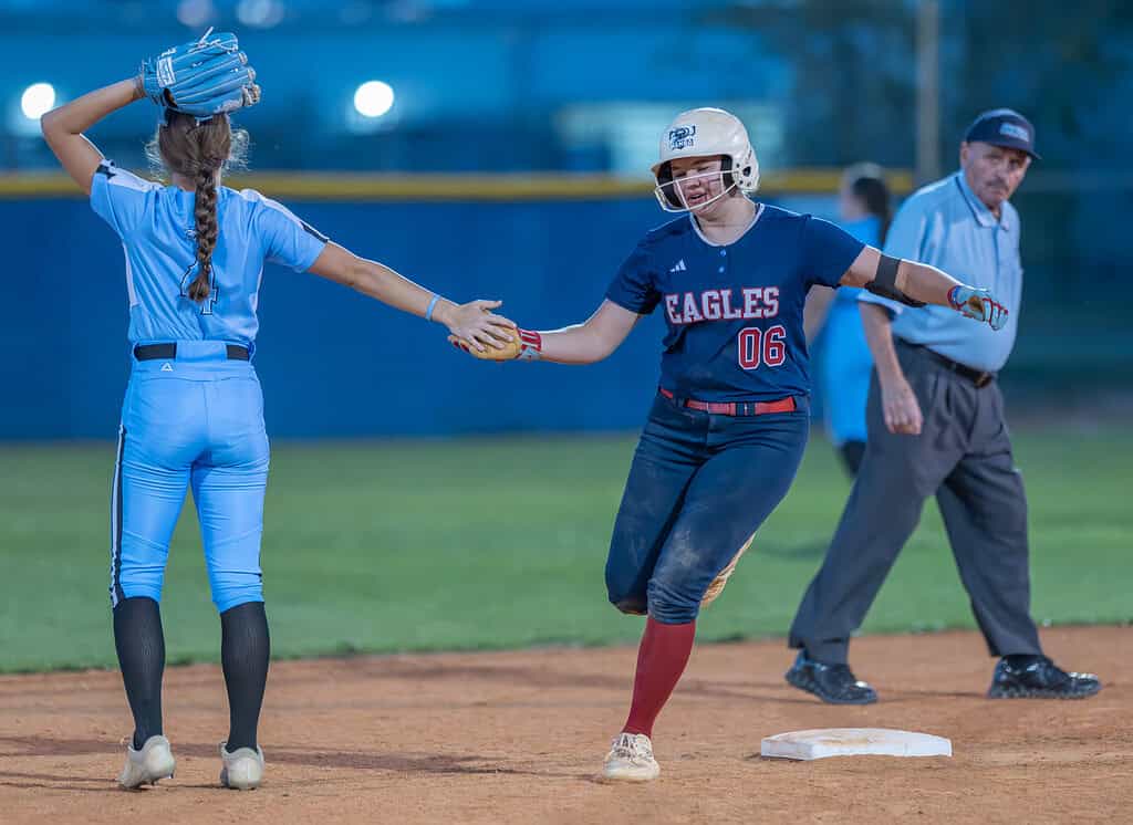 Springstead High, 06, Alivia Miller gets a hand slap from Nature Coast shortstop ,4, Maddy DePetrillo after her homerun Friday at Springstead High. [Photo by Joe DiCristofalo]