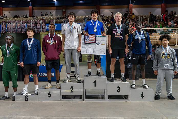 Draven McCall stands atop the podium after taking first in the 165-pound (2A) bracket at the FHSAA State Wrestling Championships. [Photo by Daniel Ward]