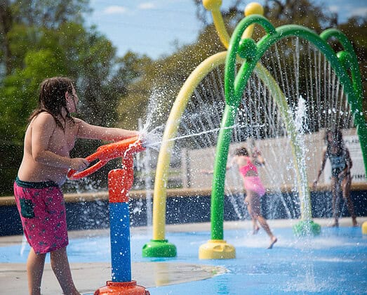 Tom Varn Park regular Winston Summers mans one of the water canons at the grand opening of the splash pad on March 1, 2025. [Photo by Jenifer Truitt]