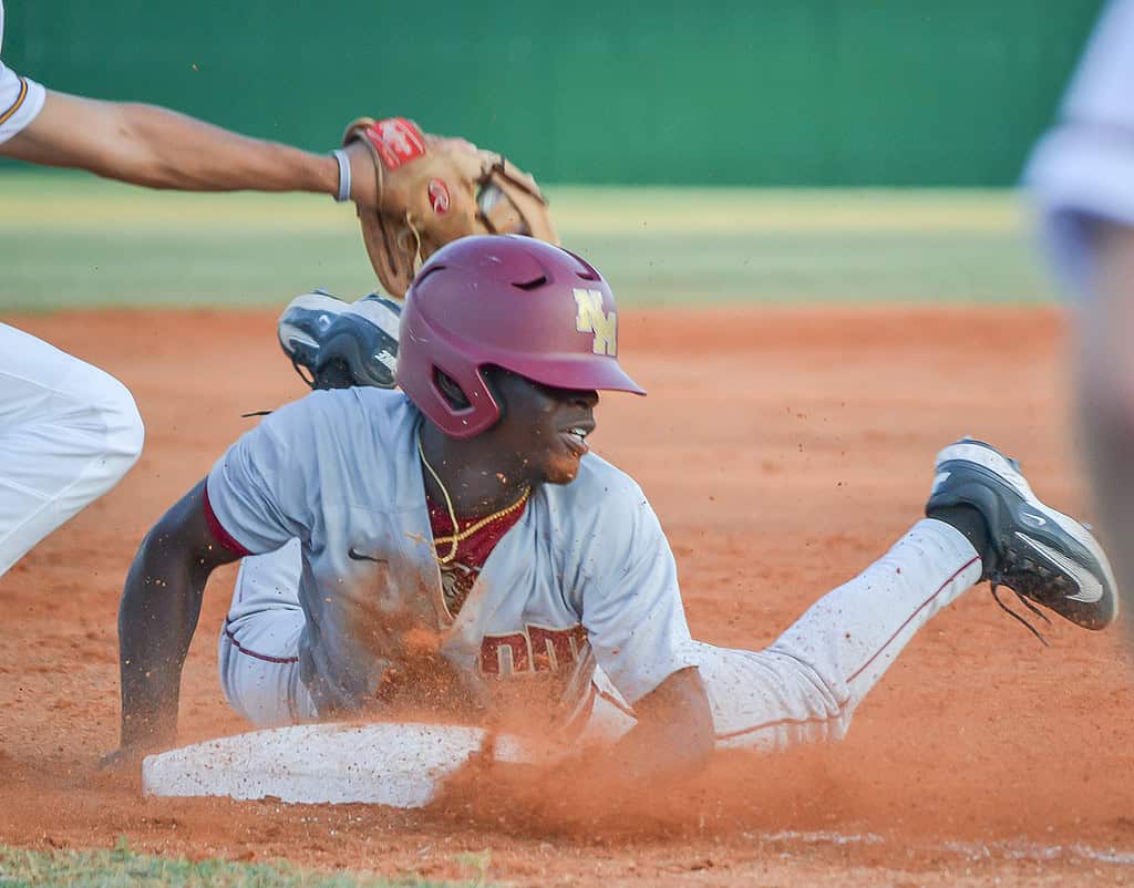 North Marion's John Collins slides into third base ahead of the tag of Hernando's Mason Morgan in Thursday's regional quarterfinal finale in Brooksville. [Credit: Chris Bernhardt Jr.]